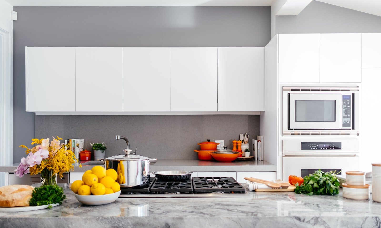 Renovated white kitchen with gray backsplash and gas cooktop