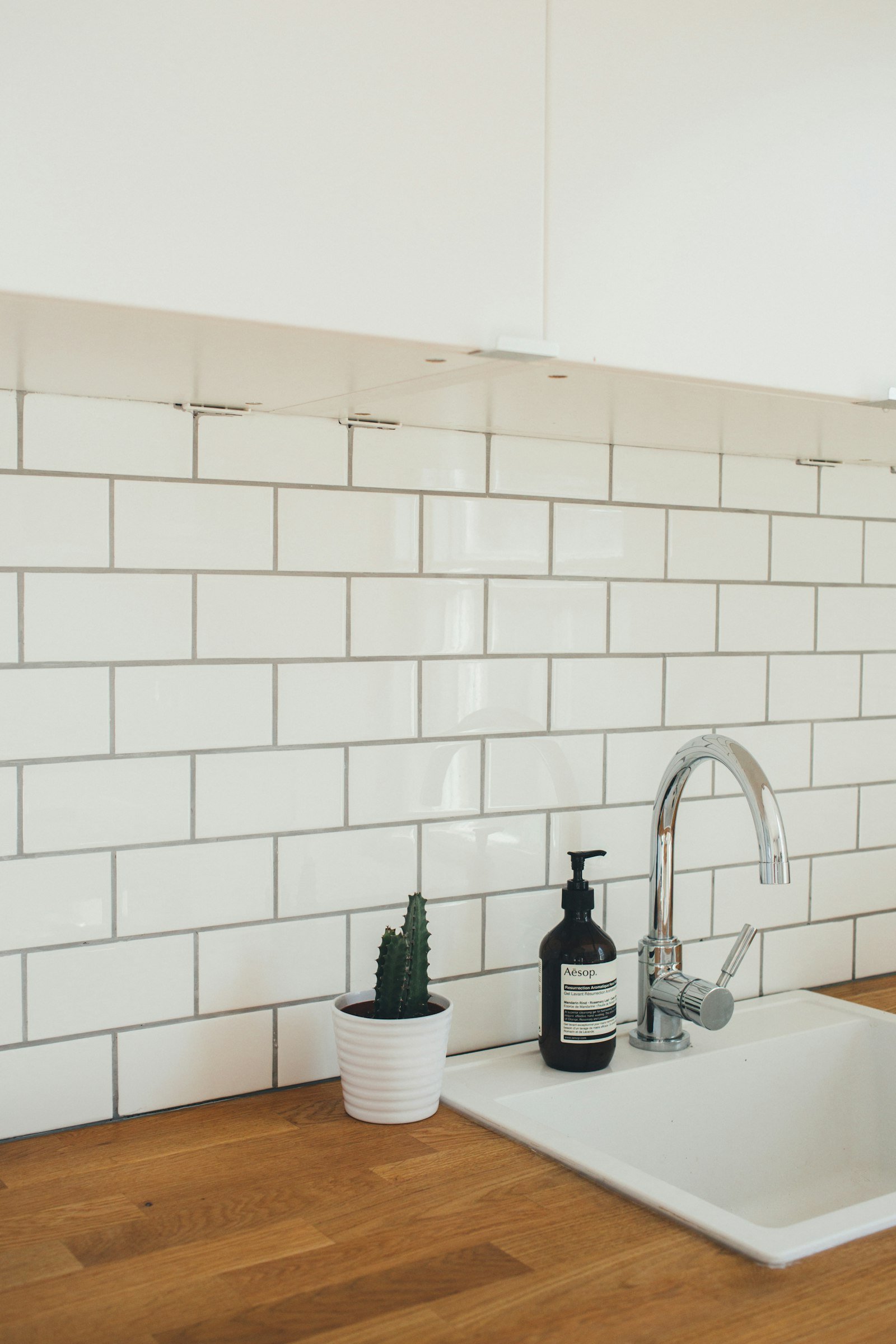 White subway tile backsplash with new faucet and sink